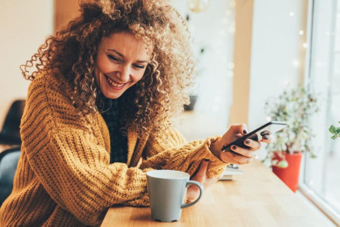 Person laughing and using a smartphone