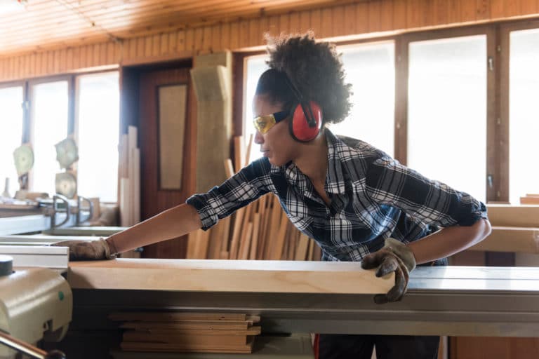Woman using a wood splicer while wearing hearing protection