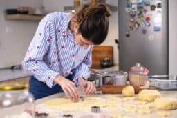 Woman with a hearing aid making cookies.