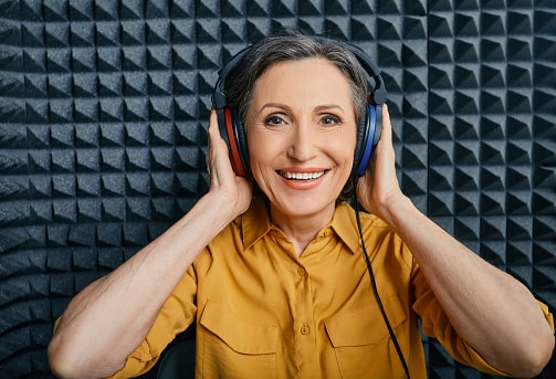 Woman wearing audiometry headphones while hearing test and audiogram in special audio room