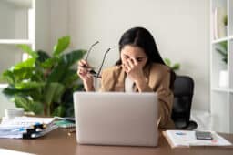 Woman looking tired at her laptop.