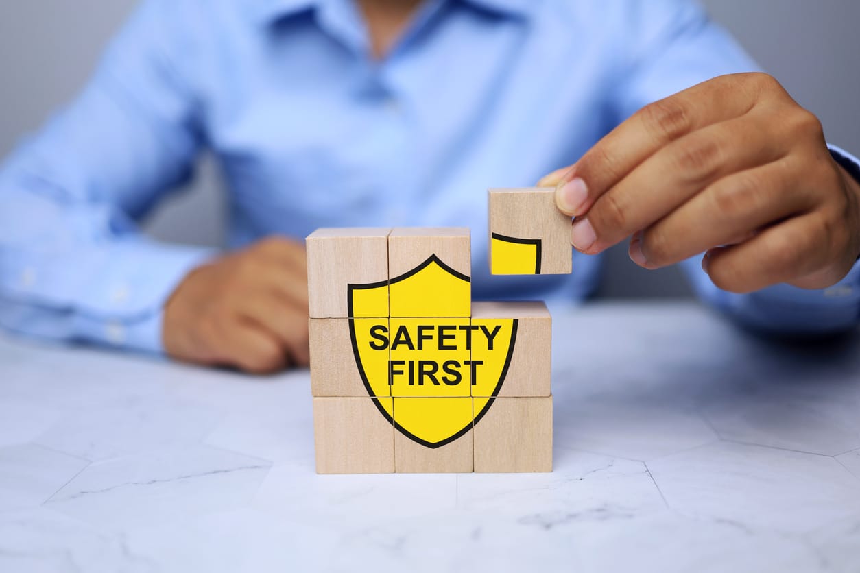 Man building a "safety first" sign out of blocks.