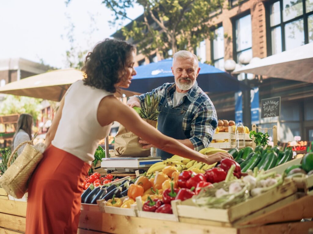 Cheerful Street Vendor Running a Small Farm Market Business, Selling Sustainable Fruits and Vegetables.