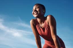 Runner standing in the sun and smiling.