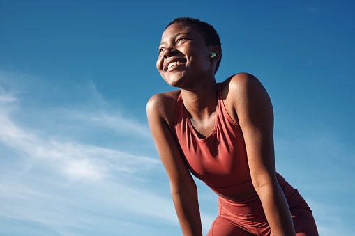 Runner standing in the sun and smiling.